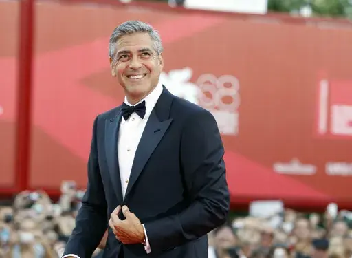 George Clooney poses on the red carpet at the premiere of his film "The Ides of March," opening the 68th edition of the Venice Film Festival in Venice, Italy on Aug. 31, 2011. (AP Photo/Andrew Medechini, File)