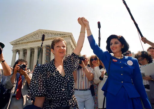Norma McCorvey, Jane Roe in the 1973 court case, left, and her attorney Gloria Allred hold hands as they leave the Supreme Court building in Washington after sitting in while the court listened to arguments in a Missouri abortion case, April 26, 1989. A leaked draft of a U.S. Supreme Court decision suggests the country's highest court could be poised to overturn the constitutional right to abortion, allowing individual states to more heavily regulate or even ban the procedure. (AP Photo/J. Scott