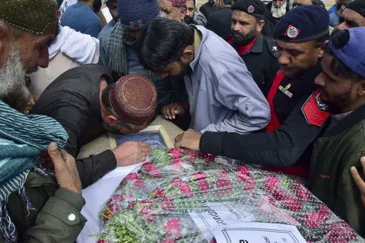 Mourners gather around a casket of a victim of a train attack, for a funeral prayer in Quetta, Pakistan's southwestern Balochistan province, Thursday March 13, 2025. (AP Photo/Arshad Butt)