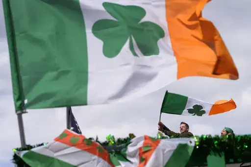 A person waves an Irish flag while watching the St. Patrick's Day parade, Sunday, March 17, 2024, in Boston's South Boston neighborhood. (AP Photo/Steven Senne, File)