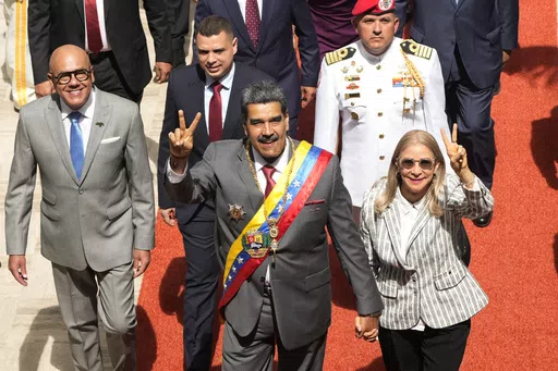 Venezuelan President Nicolas Maduro and first lady Cilia Flores flash victory signs as they arrive to the National Assembly for the annual presidential address, in Caracas, Venezuela, Jan. 15, 2024. As the July 28 presidential election nears, Venezuelan government keeps arresting opponents allegedly tied to criminal plots. (AP Photo/Ariana Cubillos, File)