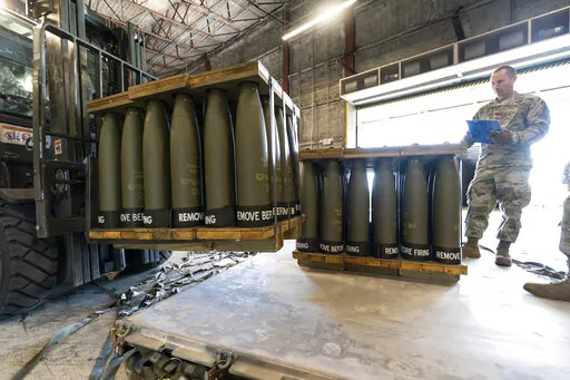 U.S. Air Force Staff Sgt. Cody Brown, right, with the 436th Aerial Port Squadron, checks pallets of 155 mm shells ultimately bound for Ukraine, April 29, 2022, at Dover Air Force Base, Del. U.S. officials say that as Russia’s war on Ukraine drags on, U.S. security assistance is shifting to a longer-term campaign that will likely keep more American military troops in Europe into the future. They say a new aid package to be announced includes an additional roughly $3 billion to train and equip U