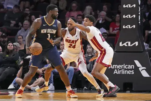 New Orleans Pelicans forward Zion Williamson (1) looks for an opening past Miami Heat forward Haywood Highsmith (24) and guard Dru Smith (12) during the first half of an NBA preseason basketball game, Sunday, Oct. 13, 2024, in Miami. (AP Photo/Wilfredo Lee)