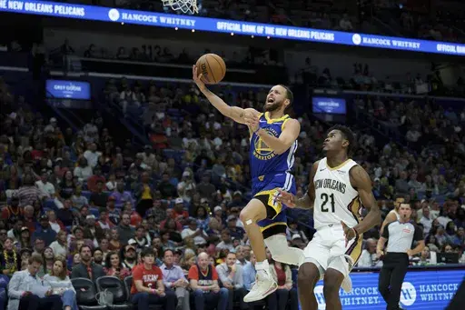 Golden State Warriors guard Stephen Curry (30) makes a basket after a foul by New Orleans Pelicans center Yves Missi (21) during the first half of an NBA basketball game in New Orleans, Friday, March 28, 2025. (AP Photo/Matthew Hinton)
