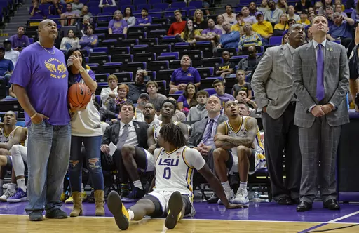 With LSU head coach Will Wade watching, right, Wayne and Fay Sims, left, watch a memorial video for their son Wayde Sims after LSU's NCAA college basketball game against Southeastern Louisina, Tuesday, Nov. 6, 2018, in Baton Rouge, La. Wayne “Big Daddy” Sims, who played in four NCAA Tournaments with LSU from 1987-1991, died Wednesday, April 13, 2023, at age 54. (AP Photo/Bill Feig)