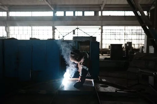 A worker welds part of a shelter in a plant of the Metinvest company, in Kryvyi Rih, Ukraine, Thursday, March 2, 2023. The plant, which is part of Renat Akhmetov's Metinvest metals and mining holding, ships metal shelters to the frontline. (AP Photo/Thibault Camus)