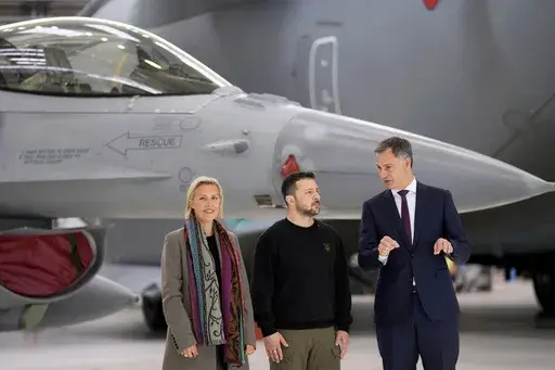 Belgium's Prime Minister Alexander De Croo, right, and Belgium's Defense Minister Ludivine Dedonder, left, pose with Ukraine's President Volodymyr Zelenskyy in front of an F-16 at Melsbroek military airport in Brussels, on May 28, 2024. Ukraine may keep some of the F-16 fighter jets it's set to receive from its Western allies at foreign bases to protect them from Russian strikes, a senior Ukrainian military officer said Monday June 10, 2024. Belgium, Denmark, the Netherlands and Norway have comm