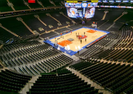 In this Oct. 24, 2013, file photo, members of the media stand on the basketball court during a tour of the newly-renovated Madison Square Garden in New York. Madison Square Garden won't host the NIT semifinals and championship game the next two years, according to a person with direct knowledge of the decision — ending a college basketball tradition that dates to 1938. The person spoke to The Associated Press on condition of anonymity late Wednesday night, March 23, 2022, because no public ann