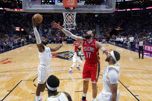 Los Angeles Lakers forward LeBron James (6) pulls down a rebound against New Orleans Pelicans center Jonas Valanciunas (17) in the first half of an NBA basketball game in New Orleans, Saturday, Feb. 4, 2023. (AP Photo/Gerald Herbert)