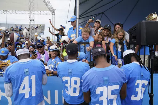 Los Angeles Chargers safety Raheem Layne (41), cornerback Cam Brown (38), cornerback Amechi Uzodinma (35) and cornerback Ja'Sir Taylor (36) sign autographs for fans during the NFL football team's training camp, Saturday, July 29, 2023, in Costa Mesa, Calif. For at least one year, Southern California will be a prime spot for NFL training camps. With the Costa Mesa City Council unanimously approving a deal with the Las Vegas Raiders, five teams, the Raiders, Chargers, Rams, Saints and Cowboys, wil
