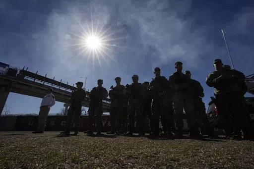 Members of the National Guard stand as Texas Gov. Greg Abbott and fellow governors hold a news conference along the Rio Grande to discuss Operation Lone Star and border concerns, Sunday, Feb. 4, 2024, in Eagle Pass, Texas. Louisiana lawmakers approved a bill Wednesday that would empower state and local law enforcement to arrest and jail people in the state who entered the U.S. illegally, (AP Photo/Eric Gay, file)