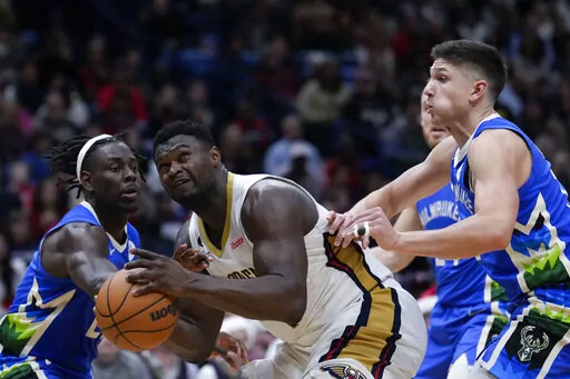 New Orleans Pelicans forward Zion Williamson goes to the basket between Milwaukee Bucks guard Jrue Holiday, left, and guard Grayson Allen in the second half of an NBA basketball game in New Orleans, Monday, Dec. 19, 2022. The Bucks won 128-119. (AP Photo/Gerald Herbert)