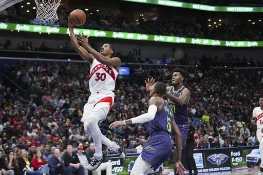 Toronto Raptors guard Ochai Agbaji (30) goes to the basket ahead of New Orleans Pelicans center Yves Missi (21) and guard Dejounte Murray (5) in the first half of an NBA basketball game in New Orleans, Wednesday, Nov. 27, 2024. (AP Photo/Gerald Herbert)