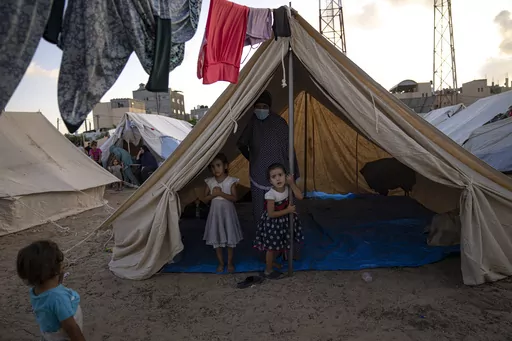 Palestinian children displaced by the Israeli bombardment of the Gaza Strip stan in a UNDP-provided tent camp in Khan Younis on Thursday, Oct. 19, 2023. Hundreds of Palestinians have crowded into a squalid tent camp in southern Gaza, an image that has brought back memories of their greatest trauma. The impromptu construction of the tent city in Khan Younis to shelter scores of Palestinians who lost or fled their homes during the past days of intense Israeli bombardment has elicited anger, disbel
