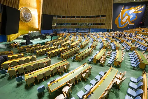 Visitors to the United Nations headquarters take photos at the General Assembly speaker's podium ahead of the General Assembly, Friday, Sept. 16, 2022. (AP Photo/Mary Altaffer)