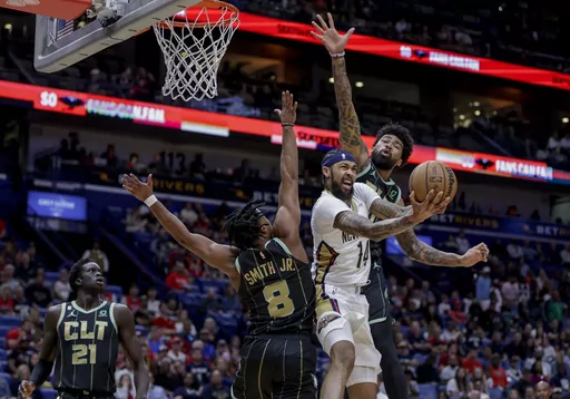New Orleans Pelicans forward Brandon Ingram (14) scores and draws a foul on shot as Charlotte Hornets guard Dennis Smith Jr. (8) and center Nick Richards (4) defend in the first quarter of an NBA basketball game in New Orleans, Thursday, March 23, 2023. (AP Photo/Derick Hingle)