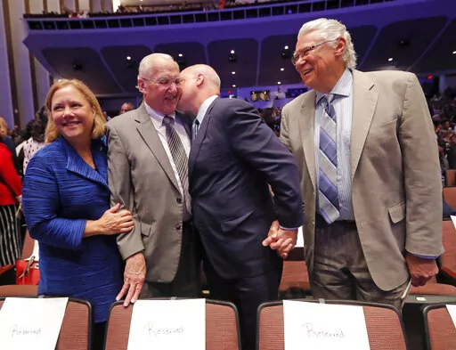 Outgoing New Orleans Mayor Mitch Landrieu kisses his father, former New Orleans Mayor Moon Landrieu, before they pose for a photo with his sister, former Sen. Mary Landrieu, D-La., and former New Orleans Mayor Sidney Barthelemy, right, before the inauguration of newly elected New Orleans Mayor Latoya Cantrell in New Orleans, Monday, May 7, 2018. Moon Landrieu, the patriarch of a Louisiana political family who was a lonely voice for civil rights until the tide turned in the 1960s, has died at age