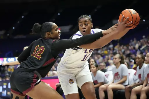 LSU forward Mikaylah Williams (12) moves the ball against Loyola New Orleans Morgan Hervey (12) in the first half an NCAA college basketball exhibition game in Baton Rouge, La., Wednesday, Nov. 1, 2023. (AP Photo/Gerald Herbert)