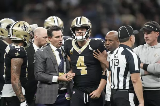 New Orleans Saints quarterback Derek Carr (4) is helped off the field during the second half of an NFL football game against the Detroit Lions, Sunday, Dec. 3, 2023, in New Orleans. (AP Photo/Gerald Herbert)