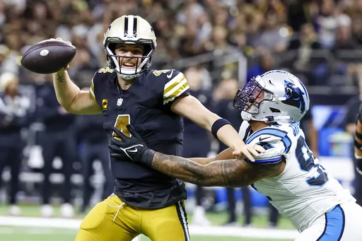 New Orleans Saints quarterback Derek Carr looks to pass under pressure by Carolina Panthers linebacker Yetur Gross-Matos during the first half of an NFL football game in New Orleans, Sunday, Dec. 10, 2023. (AP Photo/Butch Dill)