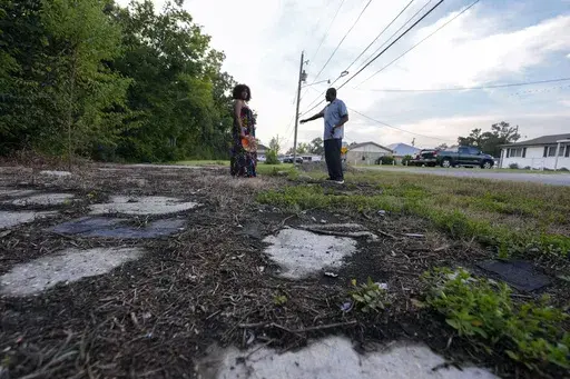 Arthur C. Blue, right, and Kimbrelle Eugene Kyereh talk about the changed landscape of the town they grew up in, alongside the IMTT facility in the Elkinsville section of St. Rose, La., Friday, Aug. 16, 2024. (AP Photo/Gerald Herbert)