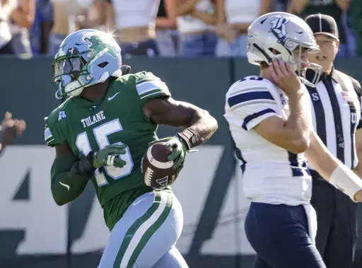 Tulane linebacker Sam Howard (15) trots past Rice quarterback E.J. Warner (13) after recovering a fumble during the first half of an NCAA football game at Yulman Stadium in New Orleans, Saturday, Oct. 19, 2024. (Scott Threlkeld/The Times-Picayune/The New Orleans Advocate via AP)