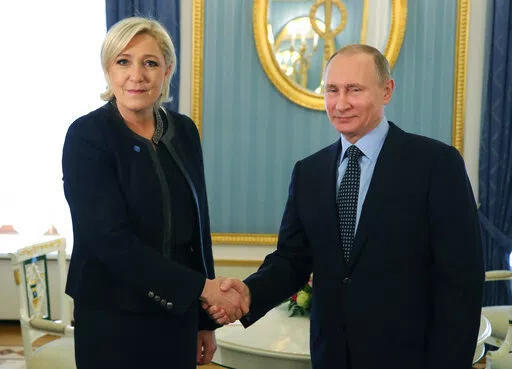 Russian President Vladimir Putin, right, shakes hands with French far-right presidential candidate Marine Le Pen, in the Kremlin in Moscow, Russia, Friday, March 24, 2017. France is thousands of miles from Ukraine, but what happens in French voting stations this month could have repercussions in Ukrainian battlefields. Nationalist candidate Marine Le Pen wants to halt arms supplies to Ukraine, improve Western ties with Russia and weaken the EU and NATO, which would undermine long-held Western al