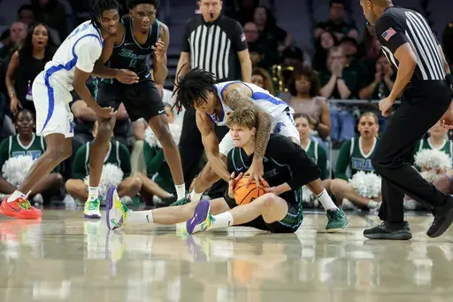 Memphis guard PJ Haggerty, top, and Tulane guard Rowan Brumbaugh, bottom, attempt to recover a loose ball during the second half of an NCAA college basketball game in the semifinals of the American Athletic Conference tournament, Saturday, March 15, 2025, in Fort Worth, Texas. (AP Photo/Gareth Patterson)