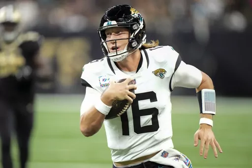 Jacksonville Jaguars quarterback Trevor Lawrence (16) runs for yardage against the New Orleans Saints in the first half of an NFL football game in New Orleans, Thursday, Oct. 19, 2023. (AP Photo/Gerald Herbert)