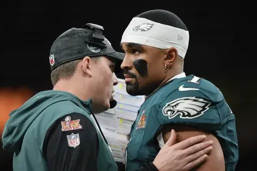 Philadelphia Eagles quarterback Jalen Hurts (1) talks to offensive coordinator Kellen Moore during the first half of the NFL Super Bowl 59 football game against the Kansas City Chiefs, Sunday, Feb. 9, 2025, in New Orleans. (AP Photo/Matt Slocum)