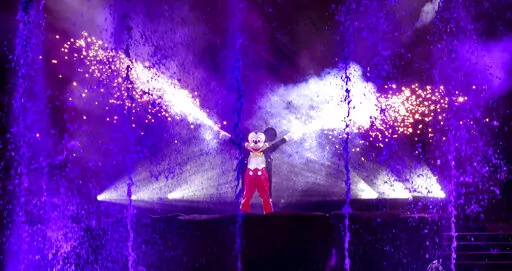 Mickey Mouse fires his fan-favorite hand sparklers during the first night of 'Fantasmic' returning to Disney's Hollywood Studios, Thursday, Nov. 3, 2022, in Lake Buena Vista, Fla. The elaborate pyrotechnics, lasers, fountains and water-screen spectacle showcases Disney characters and had been on hiatus since 2020 because of the coronavirus pandemic. (Joe Burbank/Orlando Sentinel via AP)