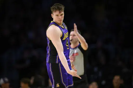 Los Angeles Lakers guard Dalton Knecht reacts after making a 3-point basket during the first half of an NBA basketball game against the New Orleans Pelicans, Friday, April 4, 2025, in Los Angeles. (AP Photo/William Liang)