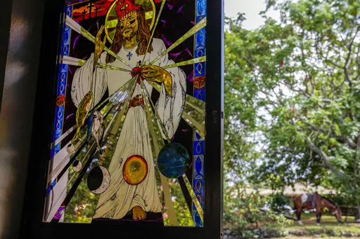 A stained glass windows depicting a Stations of the Cross scene created by French-born artist Delphine Poulain, hangs in the Holy Cross church, in Hanga Roa, Rapa Nui or Easter Island, Monday, Nov. 28, 2022. Last year, thankful for the blessings that Rapa Nui has bestowed on her, Poulain offered a gift: stained-glass windows representing the 14 Stations of the Cross in the Catholic church, located in the island’s main city. (AP Photo/Esteban Felix)