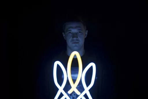 Mykhailo Fedorov, Ukrainian minister of digital transformation, poses for a photo illuminated by a lamp in the shape of a Ukrainian trident, a national symbol, in his office in Kyiv, Ukraine, Wednesday, Dec. 21, 2022. The Ukrainian government minister in charge of technology says his country has bought some 1,400 drones, mostly for reconnaissance, and is now developing air-to-air combat ones that can attack the drones Russia is using against Ukrainians. In a recent interview with The Associated 