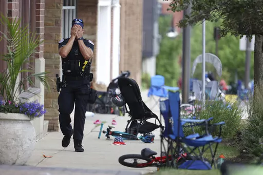 A Lake Forest, Ill., police officer walks down Central Ave in Highland Park, Ill., on Monday, July 4, 2022, after a shooter fired on the Chicago northern suburb's Fourth of July parade. Chicago is one of the nation's gun violence hotspots and a seemingly ideal place to employ Illinois' "red flag” law that allows police to step in and take firearms away from people who threaten to kill. But amid more than 8,500 shootings resulting in 1,800 deaths since 2020, the law was used there just four tim