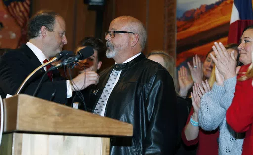 Colorado Gov. Jared Polis, left, reaches out to Rep. Tom Sullivan, D-Aurora, after his statement about the death of his son in a mass shooting at a movie theatre in Aurora during a bill signing ceremony, April 12, 2019, in the State Capitol in Denver. Colorado’s Democratic-controlled Legislature has nixed a sweeping bill Tuesday, May 7, 2024, to ban the sale and transfer of semi-automatic firearms. (AP Photo/David Zalubowski, File)