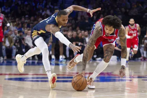 Philadelphia 76ers' Kelly Oubre Jr., right, goes after the ball against New Orleans Pelicans' Dejounte Murray, left, during the first half of an NBA basketball game, Friday, Jan. 10, 2025, in Philadelphia. (AP Photo/Chris Szagola)