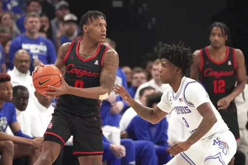 Houston guard Marcus Sasser (0) looks to pass as Memphis guard Kendric Davis (3) defends in the first half of an NCAA college basketball game Sunday, March 5, 2023, in Memphis, Tenn. (AP Photo/Karen Pulfer Focht)