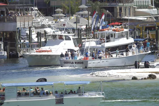In a Friday April 6, 2012 photo, charter fishing boats go in and out of Destin Harbor in Destin, Fla. An appeals court has struck down a federal fisheries management rule requiring operators of privately owned charter boats to equip their vessels with tracking devices, a victory for a group of Louisiana and Florida charter operators who challenged the rule in a 2020 lawsuit. (Nick Tomecek/Northwest Florida Daily News via AP)