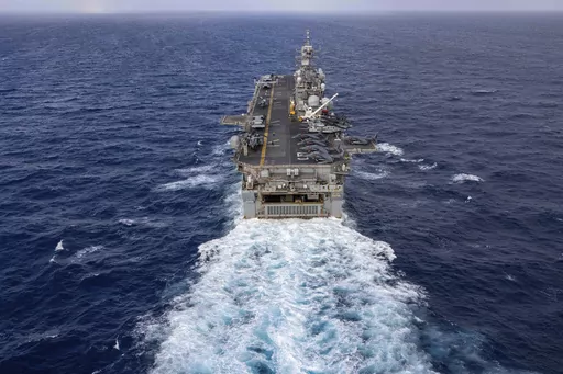 In this handout photo from the U.S. Navy, the Wasp-class amphibious assault ship USS Bataan travels through Atlantic Ocean on July 20, 2023. As thousands of Marines backed by the United States' top fighter jet, warships and other aircraft slowly building up in the Persian Gulf, the U.S. military is considering putting armed personnel on commercial ships traveling through the Strait of Hormuz, four American officials told The Associated Press on Thursday, Aug. 3, 2023. (Mass Communication Special