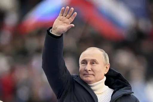 Russian President Vladimir Putin waves people after delivering his speech at the concert marking the eighth anniversary of the referendum on the state status of Crimea and Sevastopol and its reunification with Russia, in Moscow, Russia, Friday, March 18, 2022. Vladimir Putin isn't quite the man he used to be — more than a decade has passed since the Russian president engaged in public stunts to boast of his vigor by hugging a polar bear or riding a horse barechested in the mountains. (Ramil Si