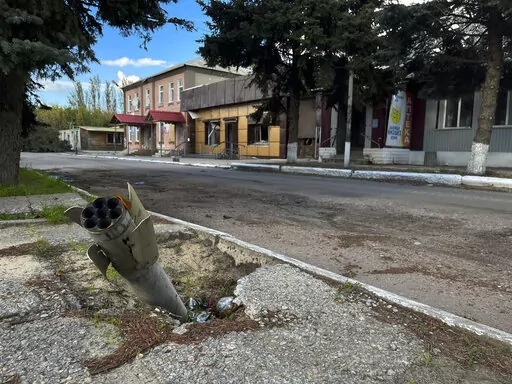 A part of a rocket sits wedged in the ground on a street in the recaptured town of Lyman, Ukraine, Friday, Oct. 7, 2022. Ukrainian authorities are just beginning to sift through the wreckage of the devastated city of Lyman in eastern Ukraine as they assess the humanitarian toll, and possibility of war crimes, from a months-long Russian occupation. (AP Photo/Justin Spike)
