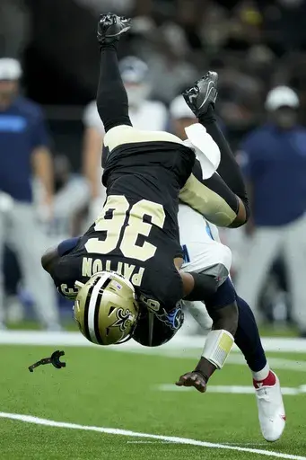 Tennessee Titans quarterback Malik Willis is tackled by New Orleans Saints cornerback Rico Payton during the second half of an NFL preseason football game, Sunday, Aug. 25, 2024, in New Orleans. (AP Photo/Gerald Herbert)
