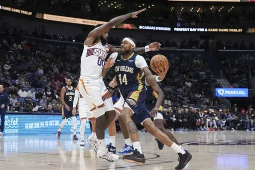 New Orleans Pelicans forward Brandon Ingram (14) drives to the basket against Phoenix Suns forward Royce O'Neale (00) in the second half of an NBA basketball game in New Orleans, Thursday, Dec. 5, 2024. The Pelicans won 126-124. (AP Photo/Gerald Herbert)