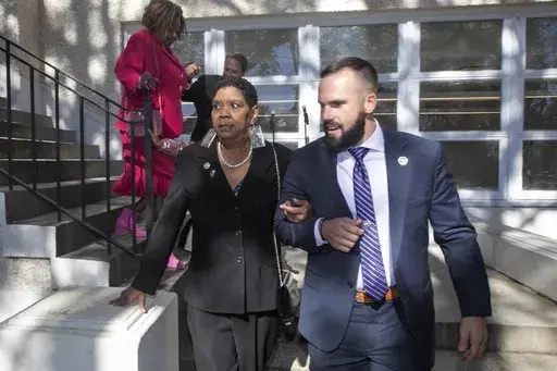 Tessie Prevost-Williams is escorted by U.S. Marshal Michael Atkins, as Gail Etienne, back left, is escorted by U.S. Marshal Brian Fair down the steps of McDonogh 19 Elementary School during the "New Orleans 4" Day 61st anniversary ceremony in New Orleans, Sunday, Nov. 14, 2021. Prevost and Etienne are two of four women who were the first African Americans to integrate the all-white public schools in New Orleans. Prevost-Williams, known as one of the “New Orleans 4,” died July 6 following a s