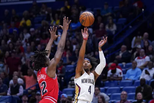 New Orleans Pelicans guard Devonte' Graham (4) shoots against Chicago Bulls guard Ayo Dosunmu (12) in the first half of an NBA basketball game in New Orleans, Thursday, March 24, 2022. (AP Photo/Gerald Herbert)
