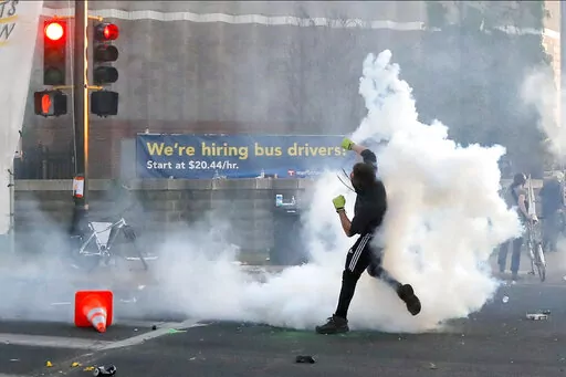 A protester launches a teargas canister back at Minnesota State Police, on May 30, 2020, in Minneapolis. George Floyd's death after his arrest by police officers in Minneapolis on May 25, 2020, sparked widespread anger after millions of people saw video of the event. The four officers at the scene were quickly fired and charged in his death. Officer Derek Chauvin was convicted of murder last year. The other three officers, Thomas Lane, J. Kueng and Tou Thao, now face a federal trial accusing the