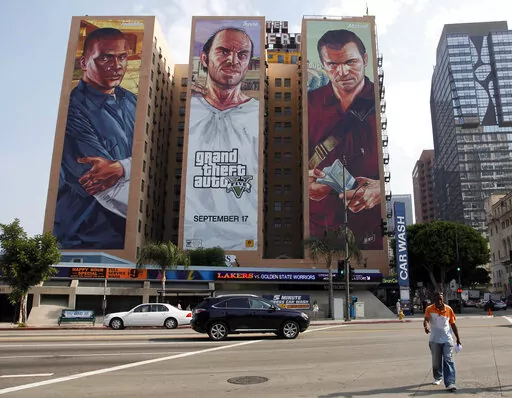 A "Grand Theft Auto V" billboard is displayed at Figueroa Hotel on Sept. 10, 2013, in Los Angeles. Video game producer Rockstar Games said Monday, Sept. 19, 2022, that early development footage from the next version of its popular title Grand Theft Auto was stolen in the hack of its network. (AP Photo/Nick Ut, File)