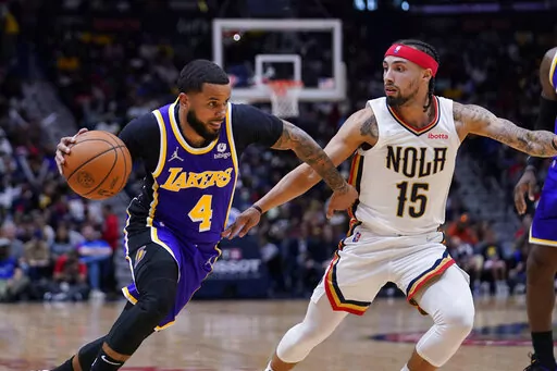 Los Angeles Lakers guard D.J. Augustin (4) drives to the basket against New Orleans Pelicans guard Jose Alvarado (15) in the first half of an NBA basketball game in New Orleans, Sunday, March 27, 2022. The Pelicans won 116-108. (AP Photo/Gerald Herbert)
