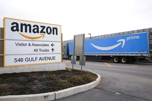 An Amazon Prime truck passes by a sign outside an Amazon fulfillment center on Staten Island, New York, on March 19, 2020. Amazon is heading into its annual Prime Day sales event on Tuesday, July 12, 2022, much differently than how it entered the pandemic. Once the darling of the pandemic economy, the company posted a rare quarterly loss in April as well as its slowest rate of revenue growth in nearly two decades at 7%. (AP Photo/Kathy Willens, File)